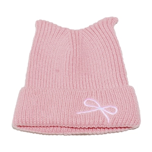 Close-up of pink knitted hat with cat ears and delicate embroidered bow details