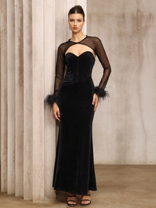 Detail of sheer mesh sleeves and black feather cuffs on a velvet evening dress