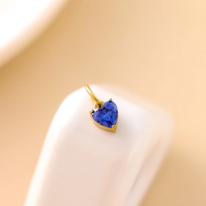 Makroansicht des herzförmigen blauen Zirkon-Anhängers in goldener Edelstahleinfassung