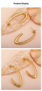 Detailed view of gold C-shaped earrings with a polished surface and retro design
