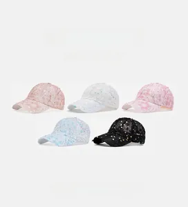 Close-up of five sequined mesh baseball caps in pink white blue and black colors
