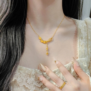 Detail einer goldenen Blumenkette mit Quasten auf dem Hals eines Models mit Spitze