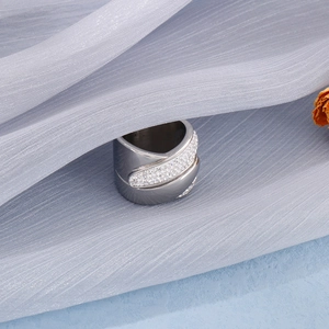 Macro shot of silver stainless steel ring with hollow cross design and pavé cubic zirconia