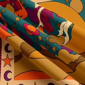 Detailed macro shot of bohemian tapestry fabric texture and colorful celestial patterns