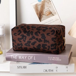 Detail of leopard print toiletry bag with textured fabric and golden zipper puller