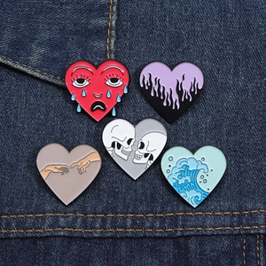Set of 5 creative heart enamel pins with skull and wave designs on denim fabric