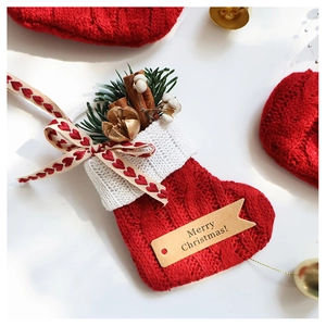 Close-up of knit Christmas stocking ornament with pine branches and cinnamon sticks