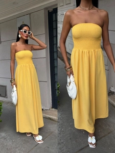 Detail of yellow smocked bodice maxi dress featuring elastic shirred waist and long skirt