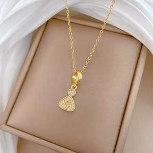 Golden titanium steel money bag necklace with pavé zircons and S initial pendant