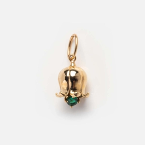 Detail of Lily of the Valley gold pendant with a green gemstone on white background