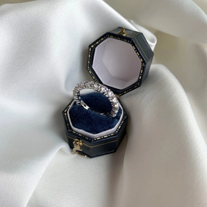 Close-up of sparkling S925 sterling silver eternity ring in a blue velvet box