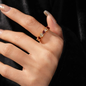 Close-up of vintage heart ring with red enamel and white zircon on a velvet background