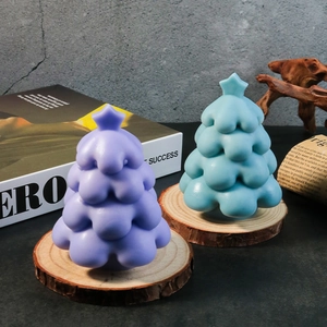 Detailed close-up of matte Christmas tree candles on a rustic wooden slice base