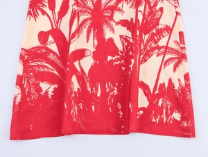 Detailed close-up of tropical palm tree print on light beige chiffon holiday dress