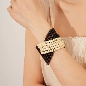 Close-up of bohemian multilayer coconut shell beaded bracelet worn on a woman's wrist