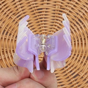 Close-up of a purple and white gradient acetate hair claw clip with golden spring