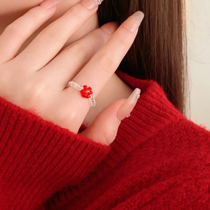 Close-up of a colorful beaded flower ring featuring transparent beads and a red floral accent