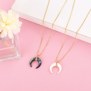 Close-up of crescent horn necklaces with colorful abalone shell and white pearly pendants