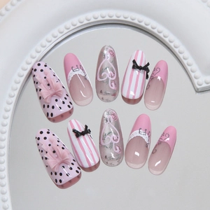 Pink French cat-eye press-on nails with 3D bows, notes and polka dots in long oval shape
