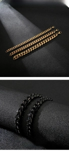 Close-up of polished gold and black stainless steel Cuban link chains with lobster clasps