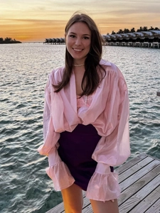 Pink chiffon long sleeve blouse with ruffle cuffs and purple mini skirt for beach vacation