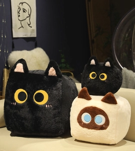Plush square cat dolls with long fur in black and beige on a cozy home sofa