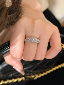 Detail eines 18K vergoldeten Ringes mit lila und weißen Zirkonia an einem Modellfinger