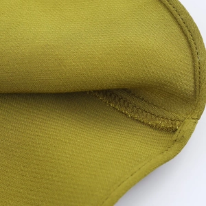 Close-up of mustard green satin dress fabric texture with fine stitching details