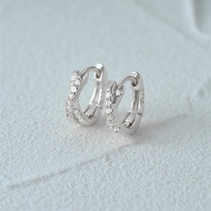 Macro detail of S925 sterling silver hoop earrings with white zircon double row cross design