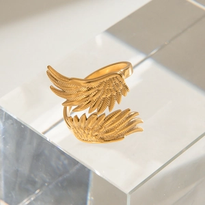 Retro golden stainless steel angel wing ring with feather texture on acrylic stand