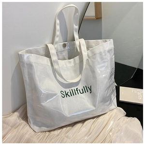 Detail of white Skillfully tote bag with clear film overlay on soft textile surface
