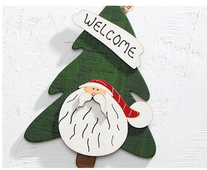 Close-up of a wooden Christmas tree welcome sign with Santa Claus and festive decor
