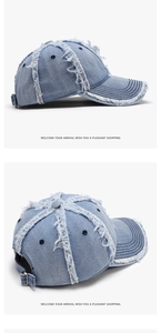 Detailed view of light blue distressed denim baseball cap with frayed edges and metal buckle