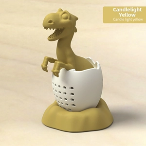 Detail view of candle light yellow dinosaur tea infuser with silicone shell and fine filter holes