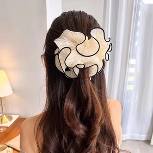 Oversized organza scrunchie in beige with black trim on a ponytail for women