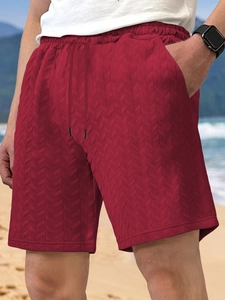 Close-up of red men's casual shorts showing jacquard fabric texture and drawstring waist