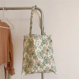 Détail du sac cabas en coton fleuri avec motif botanique et étiquette tissée fine