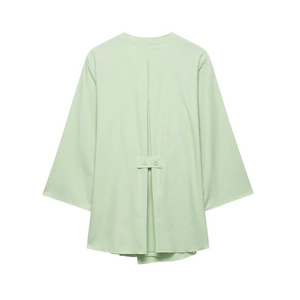Detail view of light green linen jacket back featuring pleated design and double buckle straps