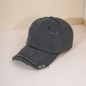 Detailed macro view of distressed grey baseball cap featuring two silver metal rings on brim