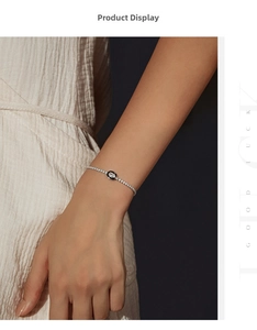 Close-up of minimalist S925 silver tennis bracelet with black enamel charm on wrist