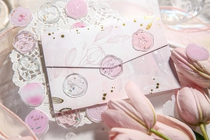 Detailed view of pink and transparent floral wax seal stickers with gold glitter accents