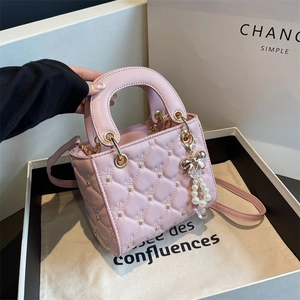 Pink quilted PU leather handbag with pearl bow charm and top handles shown with gift box