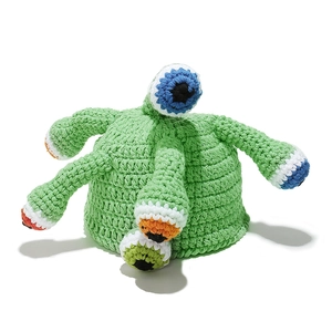 Close-up of green hand-knitted monster hat with multiple colorful eyeball details