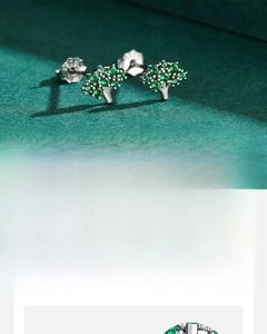 Detailed view of Tree of Life silver stud earrings with hand-set green cubic zirconia