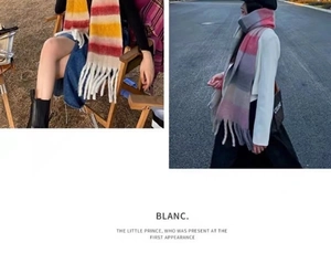 Detail showing soft rainbow plaid texture and long decorative tassels on a thick winter scarf