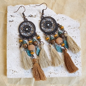 Detail of bohemian fringe earrings with beads, turquoise leaf charms and ethnic tassels
