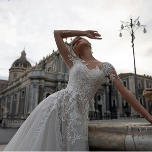 Elegant deep V-neck white lace wedding dress with intricate floral embroidery and train