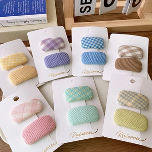 Set of colorful macaron fabric plaid hair clips for girls arranged on a desk