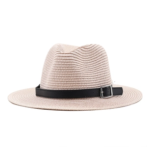 Detail of beige straw hat featuring tight weave texture and black leather band with buckle