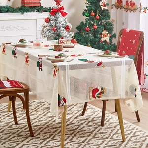 Detailed embroidery of Santa Claus and sleigh on a cream festive Christmas tablecloth